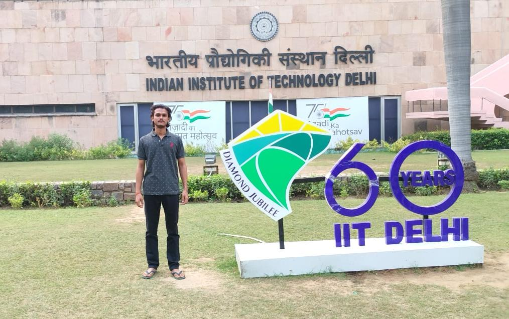 Ranjan Kumar Singh standing beside the IIT Delhi Diamond Jubilee sign